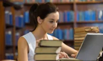student with laptop and books