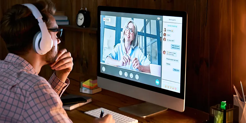 Student attending an online lesson with a teacher on screen